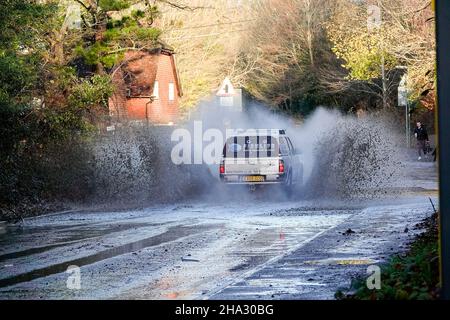 Station Lane, Godalming. 10th. Dezember 2021. Starke Regenfälle über Nacht verursachten Probleme mit Oberflächenüberflutungen in den Heimatkreisen. Fahrzeuge, die durch das Hochwasser in Godalming in Surrey fahren. Kredit: james jagger/Alamy Live Nachrichten Stockfoto