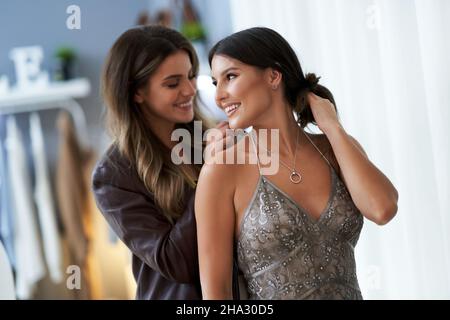 Frau, die Kleidung und Halskette mit einem Begleiter versucht Stockfoto