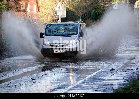 Station Lane, Godalming. 10th. Dezember 2021. Starke Regenfälle über Nacht verursachten Probleme mit Oberflächenüberflutungen in den Heimatkreisen. Fahrzeuge, die durch das Hochwasser in Godalming in Surrey fahren. Kredit: james jagger/Alamy Live Nachrichten Stockfoto