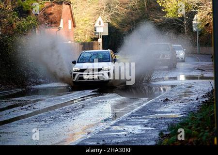 Station Lane, Godalming. 10th. Dezember 2021. Starke Regenfälle über Nacht verursachten Probleme mit Oberflächenüberflutungen in den Heimatkreisen. Fahrzeuge, die durch das Hochwasser in Godalming in Surrey fahren. Kredit: james jagger/Alamy Live Nachrichten Stockfoto