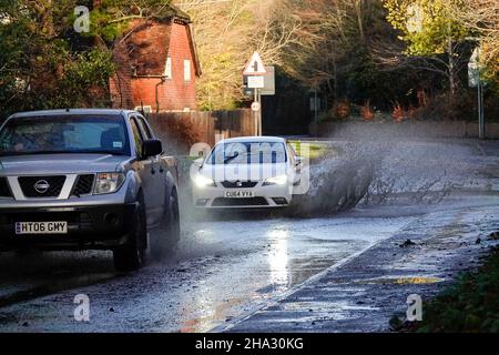 Station Lane, Godalming. 10th. Dezember 2021. Starke Regenfälle über Nacht verursachten Probleme mit Oberflächenüberflutungen in den Heimatkreisen. Fahrzeuge, die durch das Hochwasser in Godalming in Surrey fahren. Kredit: james jagger/Alamy Live Nachrichten Stockfoto