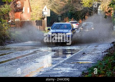 Station Lane, Godalming. 10th. Dezember 2021. Starke Regenfälle über Nacht verursachten Probleme mit Oberflächenüberflutungen in den Heimatkreisen. Fahrzeuge, die durch das Hochwasser in Godalming in Surrey fahren. Kredit: james jagger/Alamy Live Nachrichten Stockfoto