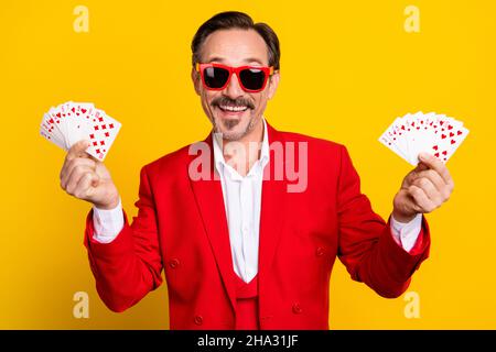Porträt von lächelnden Casino-Spieler Spieler Spieler halten Karten gewinnen Jackpot glücklichen isoliert auf gelbem Hintergrund Stockfoto