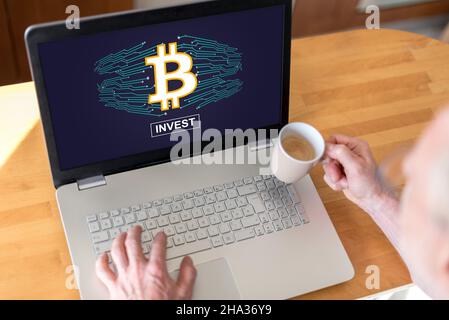 Mann mit einem Laptop mit Bitcoin-Konzept auf dem Bildschirm Stockfoto