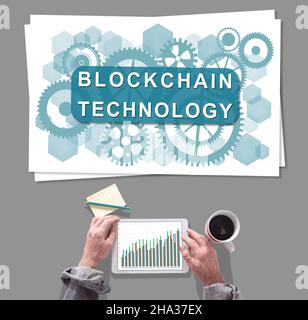 Männliche Hände mit Tablet vor dem Blockchain-Technologiekonzept Stockfoto