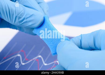 Blau poröses, schaumähnliches Material, gestreckt in den Händen des Wissenschaftlers im Labor. Forschung für Material mit neuem Eigenschaftskonzept. Stockfoto