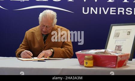 Der Prinz von Wales unterzeichnet das Besucherbuch während eines Besuches, um die neue Veterinärwissenschaftliche Fakultät der Aberystwyth University, Penglais, Aberystwyth in Ceredigion, Wales, zu eröffnen. Es ist dasselbe Buch, das er 1969 während seines Studiums an der Universität unterzeichnete. Bilddatum: Freitag, 10. Dezember 2021. Stockfoto