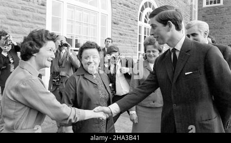 Aktenfoto vom 20/4/1969 von Miss E. Davies (links), Kantinenleiterin des University College of Wales, Aberystwyth, die Prinz Charles bei seiner Ankunft in der Pantycelyn Hall of Residence des Colleges die Hände schüttelte. Der Prinz ist zurückgekehrt, um die neue Veterinärwissenschaftliche Fakultät der Aberystwyth University zu eröffnen. Ausgabedatum: Freitag, 10. Dezember 2021. Stockfoto