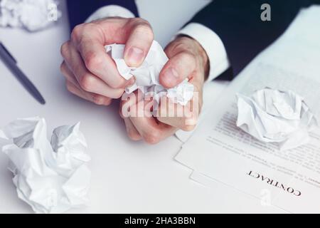 Gestresster Geschäftsmann zerbröckeln Papiervertrag und Dokumente - gescheiterte Deal und Krise Konzept. Stockfoto