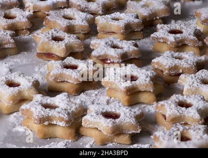 Ein Backblech voller sternförmiger Shortbread-Kekse mit Marmelade und Puderzucker-Weihnachtsplätzchen Stockfoto