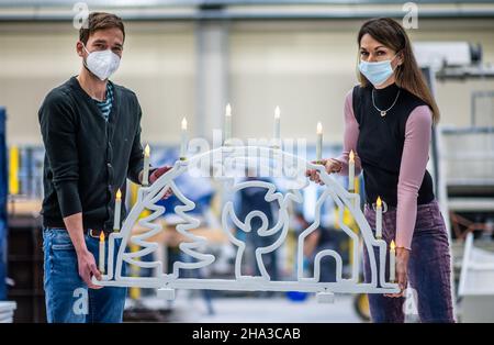 10. Dezember 2021, Sachsen, Chemnitz: Sandra Gelbrich, Leiterin des Forschungsbereichs "Leichtbau im Bauingenieurwesen" an der TU Chemnitz, und Arbeitsgruppenleiter Enrico Rudolph zeigen einen Betonflieger, der mit einem automatisierten 3D-Druckverfahren hergestellt wurde. Seit fünf Jahren forschen die Wissenschaftler am Institut für Leichtbau der Technischen Universität Chemnitz an automatisierten additiven Fertigungstechnologien. Vor kurzem präsentierten sie den weltweit ersten 3D-gedruckten Beton-Schwimmbogen. Eine spezielle Faserbeton-Formel wird in mehreren Schichten aufgetragen Stockfoto