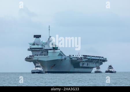 Dezember 2021, HMS Queen Elizabeth bei der Ankunft im Solent. Die Crew ist bei der Prozedur Alpha am Deck. Mit SERCO-Schleppern zum Hafen begleitet Stockfoto