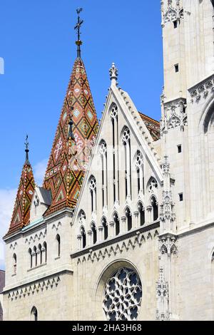 Blick auf das kunstvoll geflieste Dach der St. Matthias Kirche auf blauem Himmel im Hintergrund. Fischerbastei in Budapest, Ungarn. Stockfoto