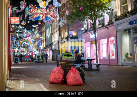 LONDON - 1. NOVEMBER 2021: Müllsäcke stapelten sich auf der Carnaby Street unter den Weihnachtsdekorationen Stockfoto
