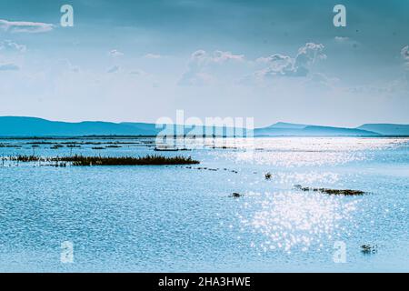 Bergsee mit perfektem blauem Ozean wunderschöne Landschaft mit Glitzerlicht, das im Wasser reflektiert wird. Natur Seenlandschaft Stockfoto