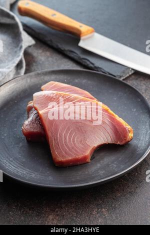 Rohes Thunfischsteak. Rohes Fischfleisch auf schwarzem Tisch. Stockfoto