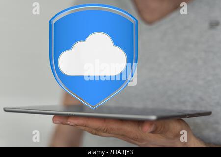 3D gerenderte Wolke Symbol über einer Tablette in einer männlichen Hand Stockfoto