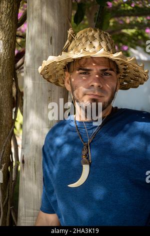 Junge Erwachsene kaukasischen Mann und Hippie-Gärtner Aussehen mit ernstem Blick im Park. Freier Speicherplatz zum Schreiben. Stockfoto