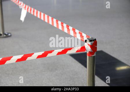 Rote und weiße Warnlinien des Schutzbandes verbieten den Durchgang, gefährliche Bereiche, Komm nicht herein. Stockfoto