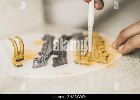 Koch mit einem Pinsel, um einige Elemente zu dekorieren, um einen Kuchen zu garnieren Stockfoto