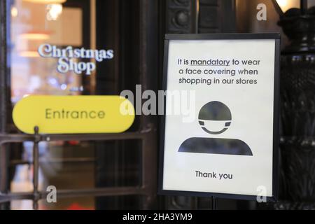 London, Großbritannien, Dezember 10th 2021. Ein Schild vor dem Selfridges Christmas Shop in der Oxford Street als der erste Teil des Covid Plan B begann, sind Gesichtsbezüge nun in allen Innenräumen obligatorisch, um die Ausbreitung der Omicron-Variante zu verhindern. Monica Wells/Alamy Live News Stockfoto