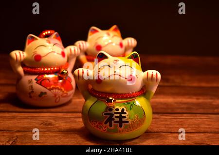 Japanische winkende Katzen (Manekineko) aus Porzellan. Sie sind traditionelle Symbole für Viel Glück. Stockfoto