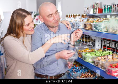 .Portrait der Familie paar Auswahl Vielfalt Süßigkeiten in Zellophan Tasche im Geschäft.. Stockfoto