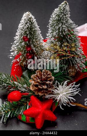Schöne Weihnachtsdekoration mit verschneiten Tannen, Pinienkegel und rotem Stern Stockfoto