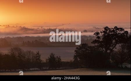 Wintersonnengang mit Schloss Windsor, das am Horizont aus dem Nebel auftaucht Stockfoto