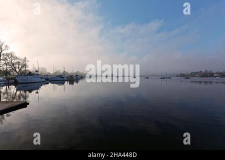 Oulton Broad bei Dämmerung mit Nebel und Reflexionen auf dem Wasser. Stockfoto