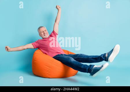 In voller Länge Körpergröße Foto Ältester Mann legt kühl auf Arbeitspause auf Sitzsack überglücklich isoliert pastellblau Farbe Hintergrund Stockfoto