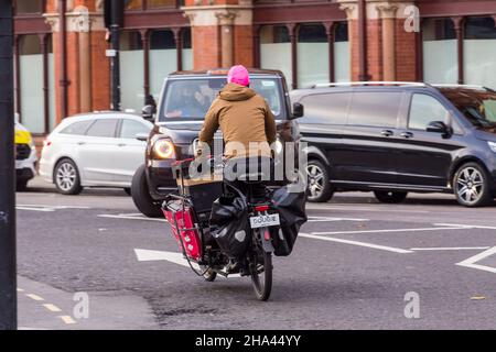 Ein Lastenrad fährt am Bahnhof St. Pancras vorbei, der voll beladen ist mit Paketen und Paketen, die in London, England, Großbritannien, geliefert werden. Stockfoto