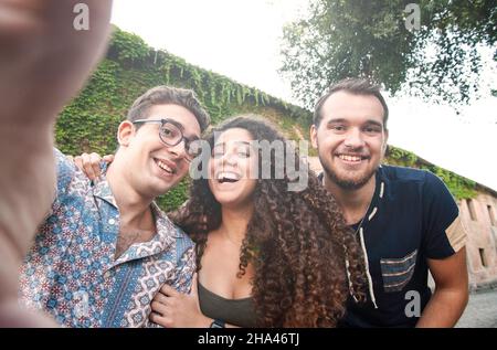 Glückliche Freunde aus verschiedenen Kulturen und Rassen beim Selfie - drei Studenten haben Spaß mit den Technologietrends an der erasmus-Universität - heller Filter - Stockfoto