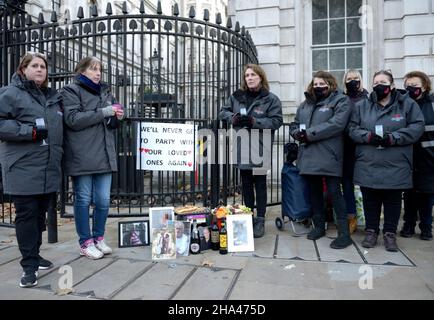 London, Großbritannien. 10th Dez 2021. Mitglieder von „Covid-19 Hinterbliebene Familien für Gerechtigkeit“, die während der Sperre Familienmitglieder verloren haben, stellen Passanten Käse und Wein vor den Toren der Downing Street zur Verfügung, als Protest gegen die Parteien, die angeblich letztes Jahr in der Nummer 10 abgehalten wurden. Quelle: Phil Robinson/Alamy Live News Stockfoto