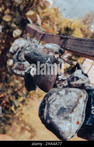 Im Sommer hängen Steine oder Hühnergötter an einem Seil an der frischen Luft Stockfoto