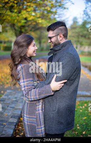 Umarmen glücklichen weißen jungen europäischen Mann und Frau im Herbst Park Stockfoto