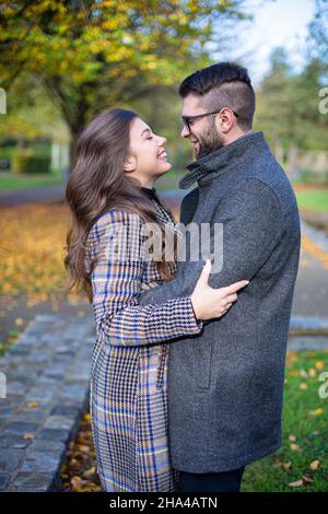Umarmen glücklichen weißen jungen europäischen Mann und Frau im Herbst Park Stockfoto