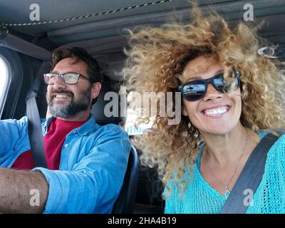 Portrait von fröhlichen kaukasischen Paar genießen Roadtrip im Auto während des Urlaubs. Aufgeregt Paar im Auto sitzen und genießen ihre Reise für den Urlaub Stockfoto