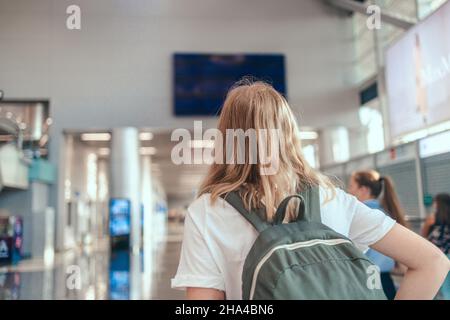 Blonde Haare weibliche Touristen Hand hält Pass mit Koffer Gepäck Wartebereich des Flughafenterminals für eine Reise. Reisen Stockfoto