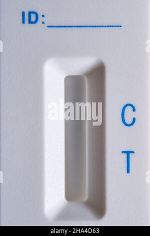 Detail der Covid-19-Antigentestkassette aus weißem Kunststoff ohne Testergebnis. Blaue Buchstaben und roter Streifen. ID-Leerzeile. Vorderansicht. Nahaufnahme. Mac Stockfoto