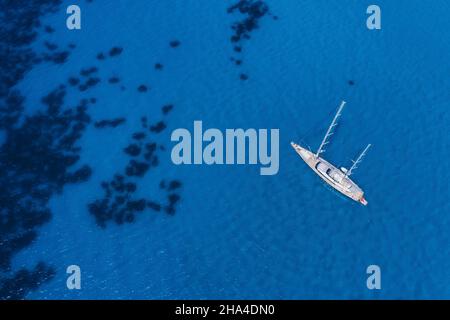 lefkada, griechenland. Abgelegener weißer egremni-Strand mit einsamem Luxus-Yacht-Boot auf der türkisfarbenen Bucht am ionischen Meer. Stockfoto