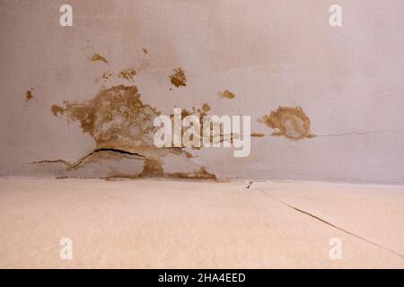 Braune Flecken an der Decke in einem Wohngebäude. Defekte Abwasserleitungen verursachen Wasserschäden. Die Sanierungsarbeiten und die Gebäudetrocknung sind die folgenden Stockfoto