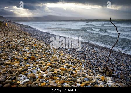 Strand mit stürmischem Meer und dunklen Wolken und einem Sonnenstrahl am Strandhill, Sligo, Irland Stockfoto