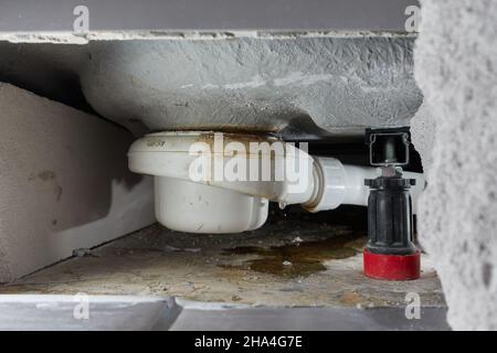 Ein undichter Siphon einer Duschwanne im Badezimmer verursacht Wasserschäden. Fliesen und Mauerwerk wurden zur Reparatur und zum Trocknen der Konstruktion entfernt. Die Ursache ist Stockfoto