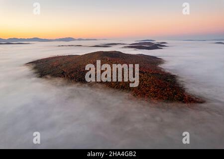 Berg bedeckt mit Herbstlaub erhebt sich über Nebel, Vermont Stockfoto