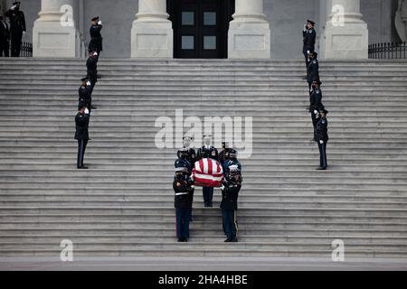 WASHINGTON, DC - 10. DEZEMBER: Ein militärischer Ehrengarde des gemeinsamen Diensts trägt die Schatulle des verstorbenen Senators Robert Dole (R-KS) die Stufen des US-Kapitols hinunter, nachdem er am 10. Dezember 2021 in Washington, DC, im Staat gelegen hatte. Dole, ein Veteran, der im Zweiten Weltkrieg schwer verletzt wurde, war von 1969 bis 1996 republikanischer Senator aus Kansas. Er kandidierte dreimal für den Präsidenten und wurde 1996 republikanischer Kandidat für das Präsidentenamt. (Foto von Anna Moneymaker/Pool/Sipa USA) Stockfoto