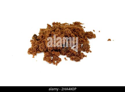 RAW Cane Sugar isoliert o weißen Hintergrund. Stapel von dunkelbraunem weichem Zucker, isoliert. Natürlicher dunkler Muscovado. Stockfoto