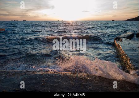 Planschende Welle an der kroatischen Küste während des Sonnenuntergangs Stockfoto