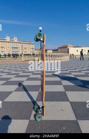 Ein Skateboard auf terrazza mascagni in livorno, italien. Es ist ein breites, gewundenes belvedere zum Meer hin mit einer Pflasterfläche von 8700 qm wie ein Schachbrett und 4,100 Balustern Stockfoto