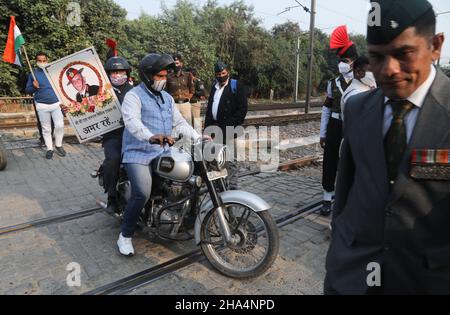 Neu-Delhi, Indien. 10th Dez 2021. Ein Motorradfahrer hält das Plakat des Stabs der Verteidigung (CDS) während der Trauerprozession.General Bipin Rawat, seine Frau Madhulika und 11 weitere Soldaten der Streitkräfte verloren ihr Leben bei einem Absturz des Hubschraubers Mi-17V5 der indischen Luftwaffe in Coonoor, Tamil Nadu. CDS Bipin Rawat wurde auf dem Bar Square in Delhi Cantonmet mit vollen militärischen Ehren eingeäschert. Kredit: SOPA Images Limited/Alamy Live Nachrichten Stockfoto